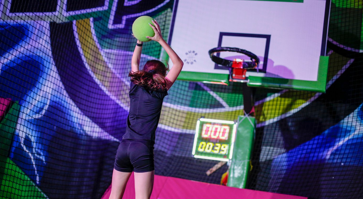 A child aims at the basket playing Slamball at Flip Out UK
