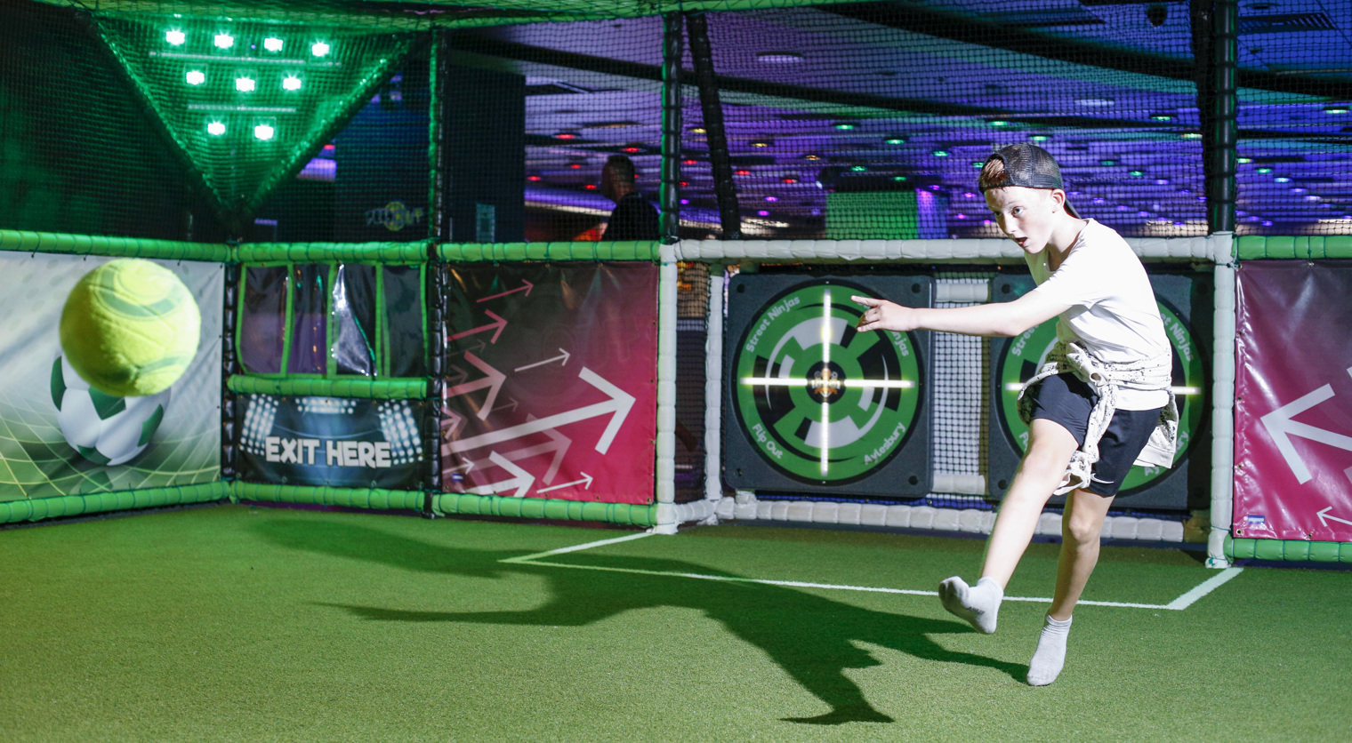A child taking aim at an interactive target with a football