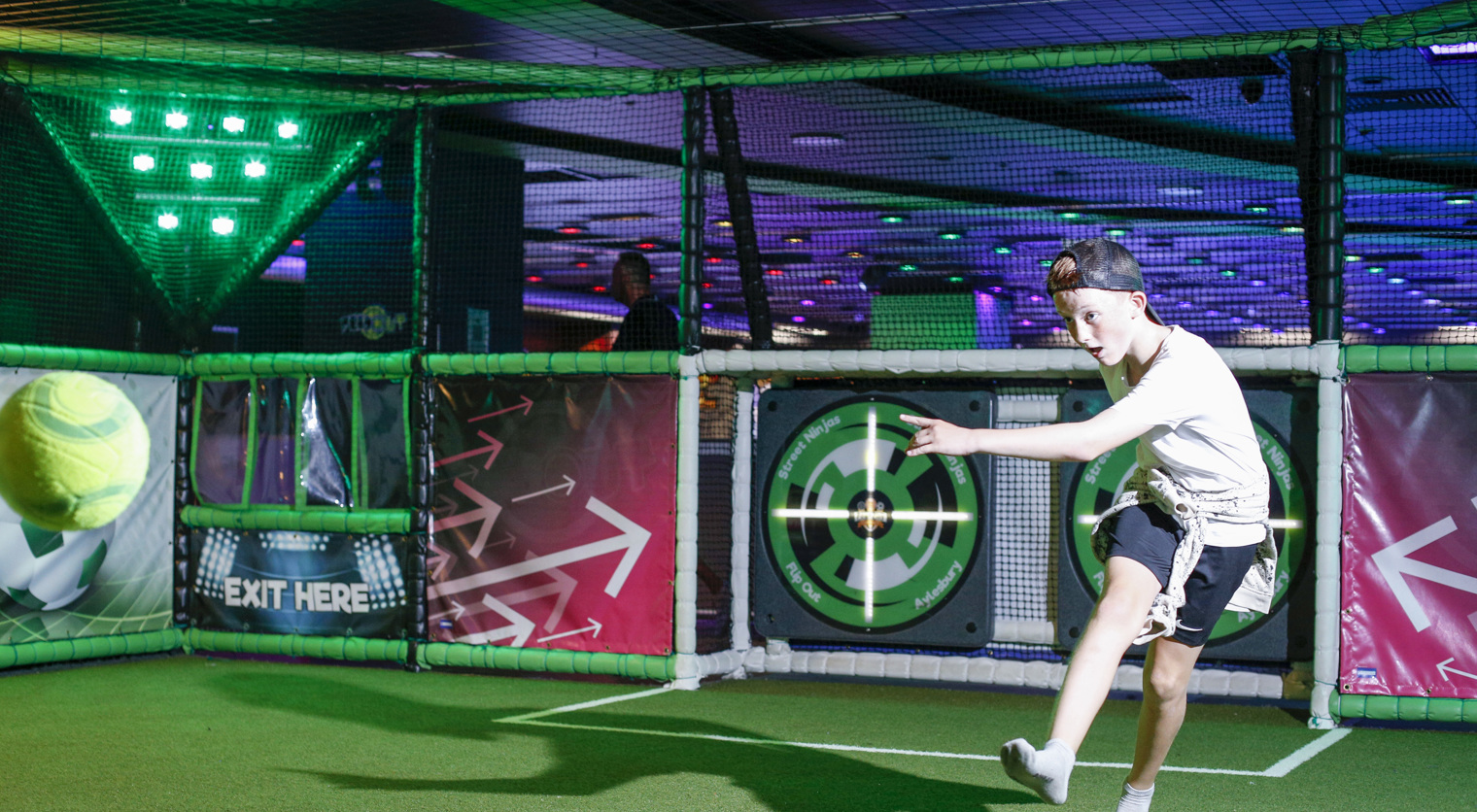 A child taking aim at an interactive target with a football