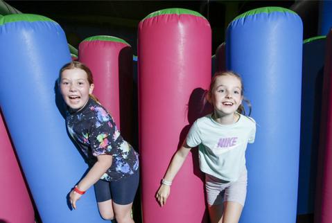 Girls at Flip Out Glasgow having fun on the giant inflatable. 