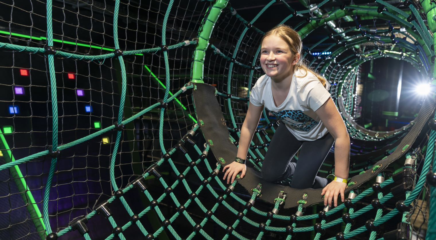 A child crawling through the Ninja Tag arena at Flip Out UK
