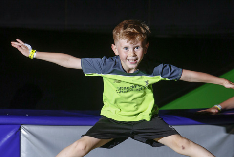 Child jumping high on a trampoline.